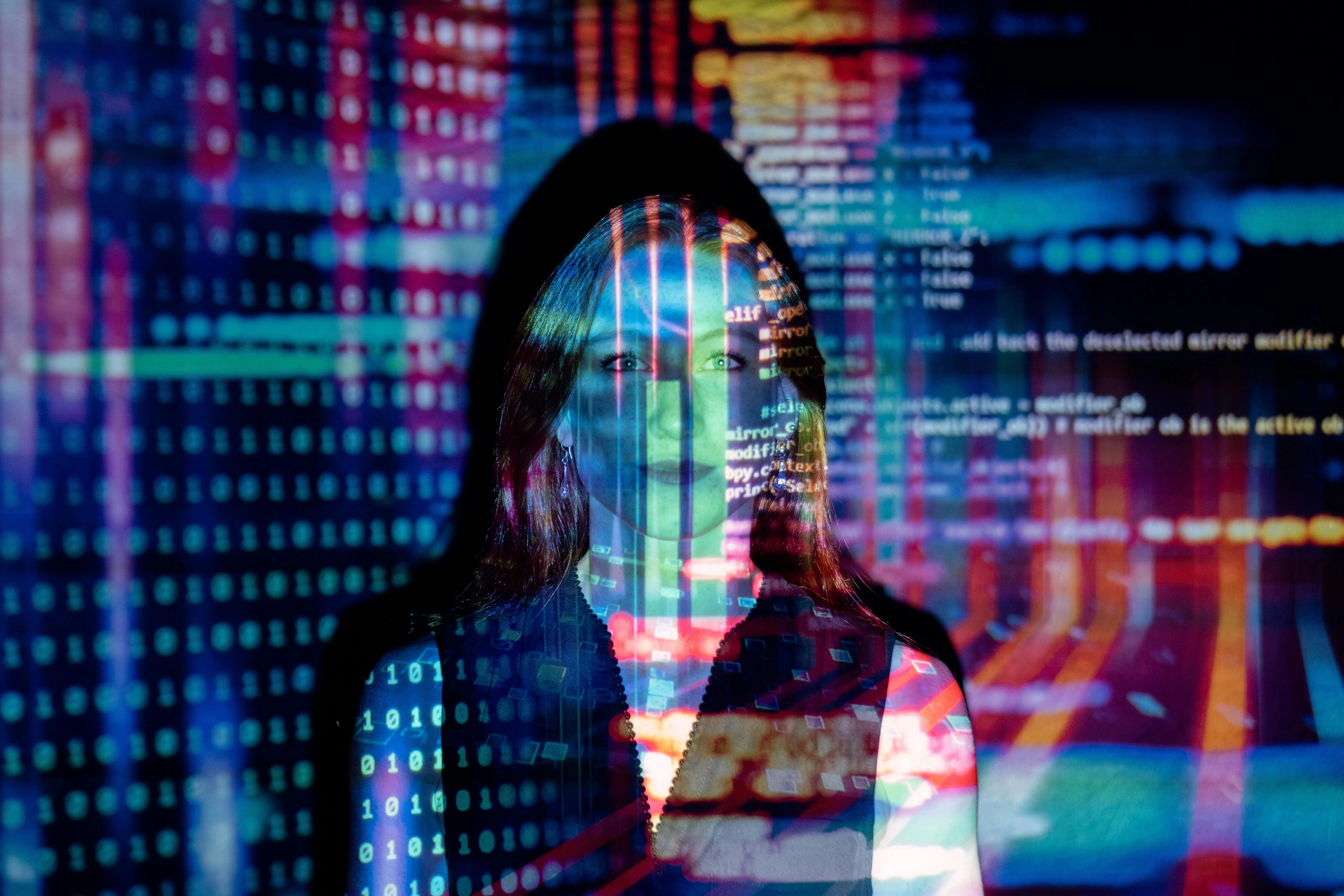 A person's face overlaid with colorful digital code and data patterns, symbolizing technology and AI.